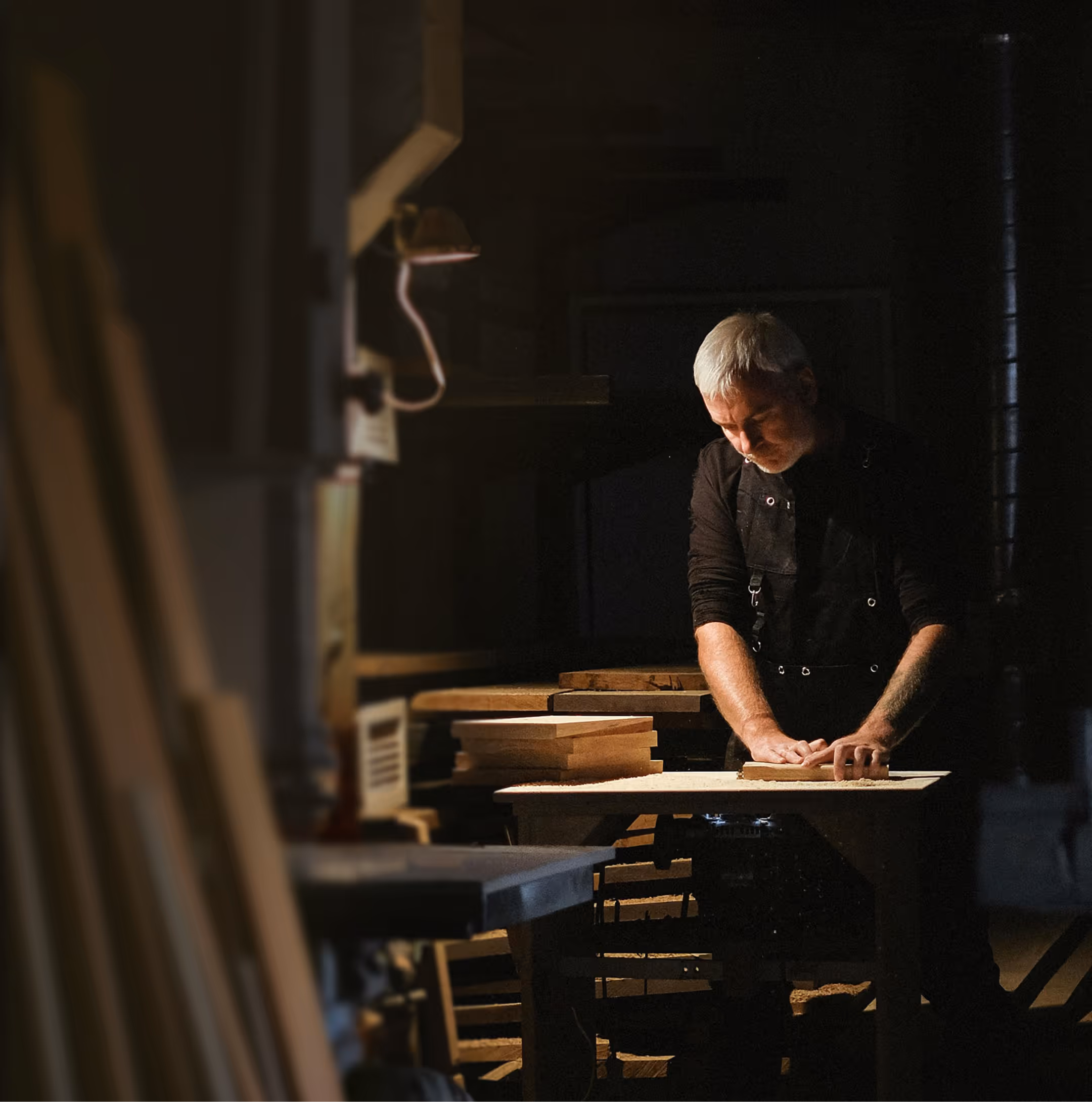 Craftsperson working with wood in a workshop.